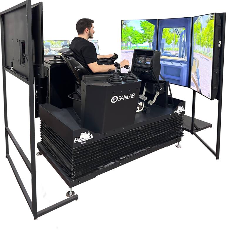 A view of an operator seated in a dozer simulator, designed with a seating arrangement similar to a real dozer cab. The simulator is surrounded by three large screens displaying outdoor scenes, such as a construction site or a forested road.